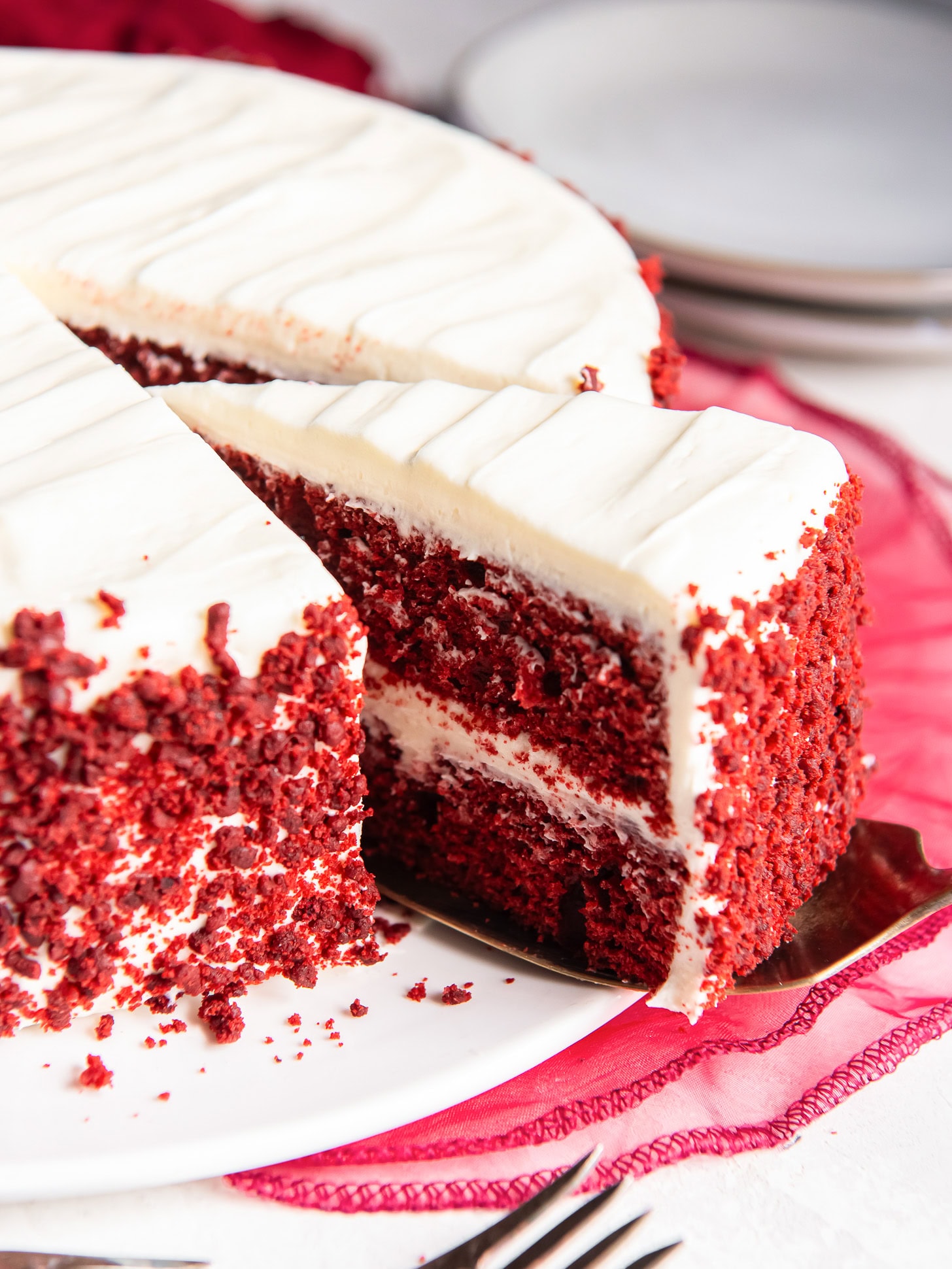 Serving a slice of red velvet cake.
