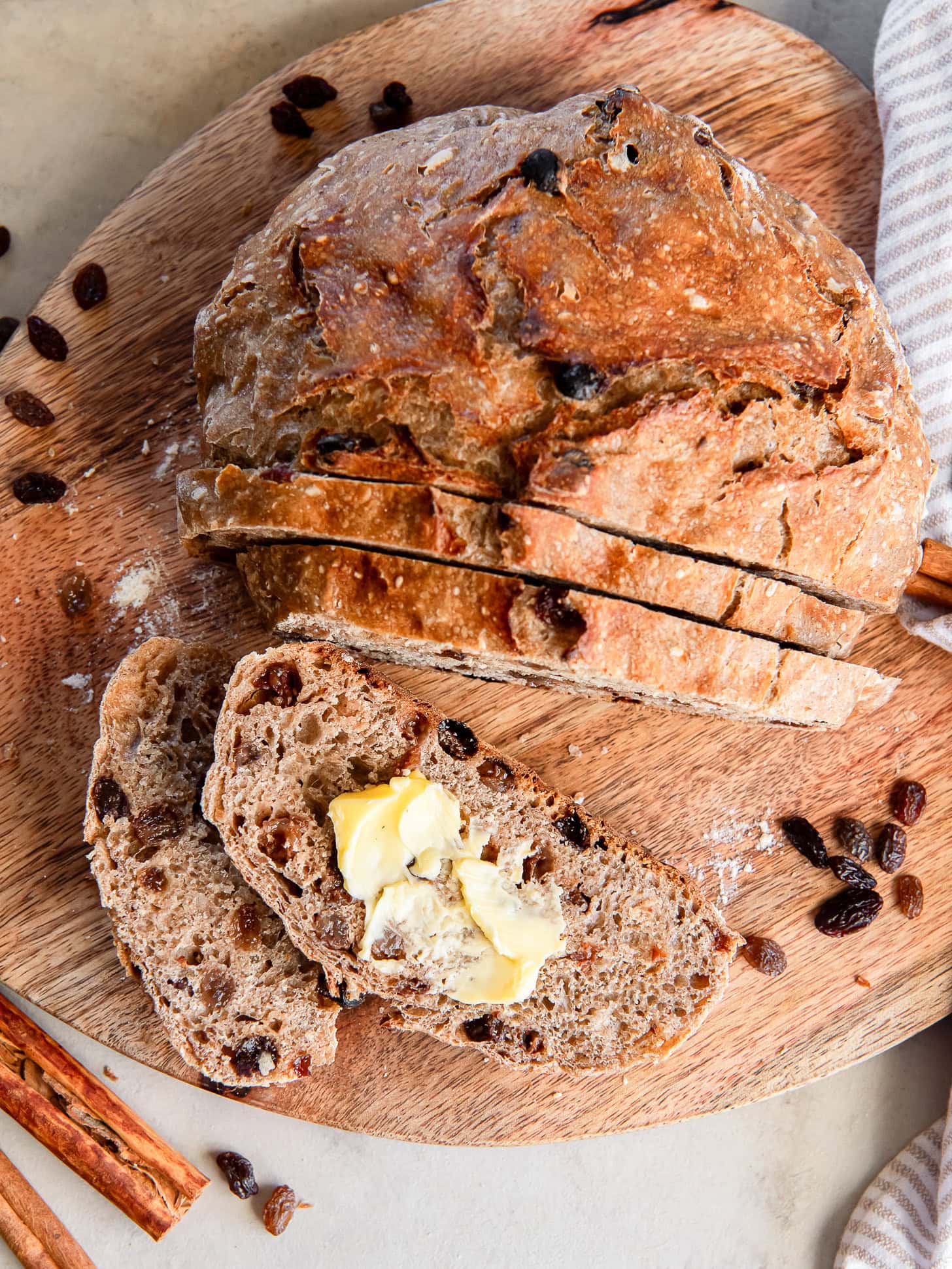 Sliced cinnamon raisin bread topped with butter.