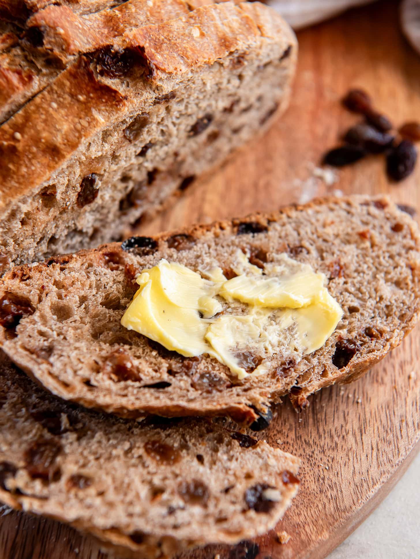 Slice of raisin bread with a smear of butter. 