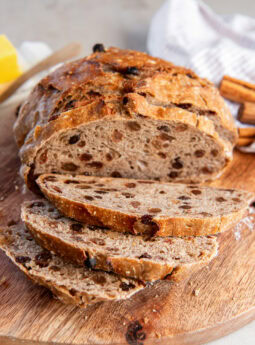 No knead cinnamon raisin bread sliced on a cutting board.