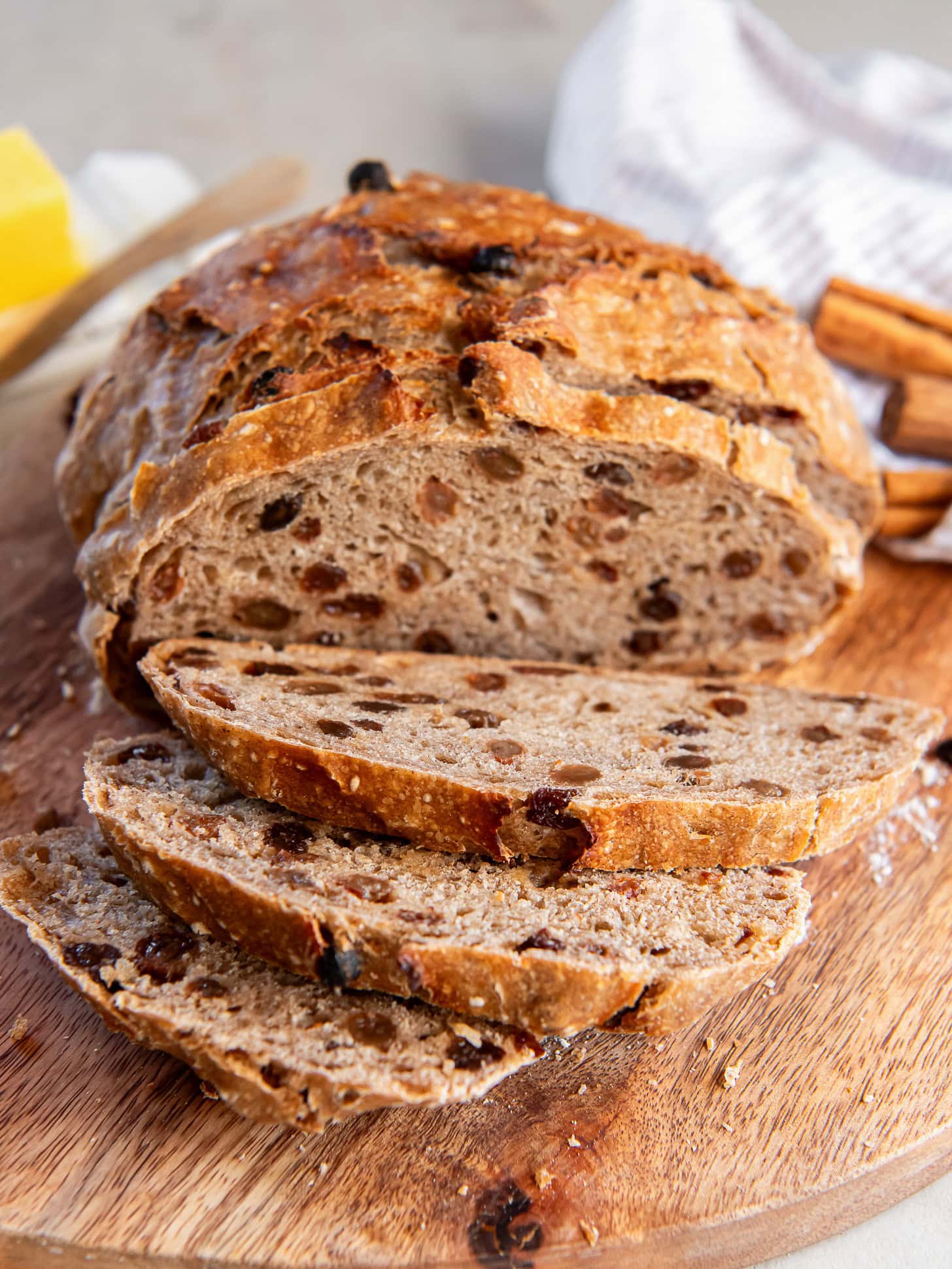No knead cinnamon raisin bread sliced on a cutting board.