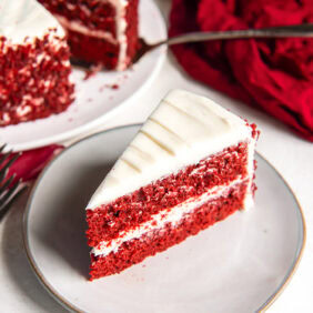 Slice of red velvet cake on a white plate.