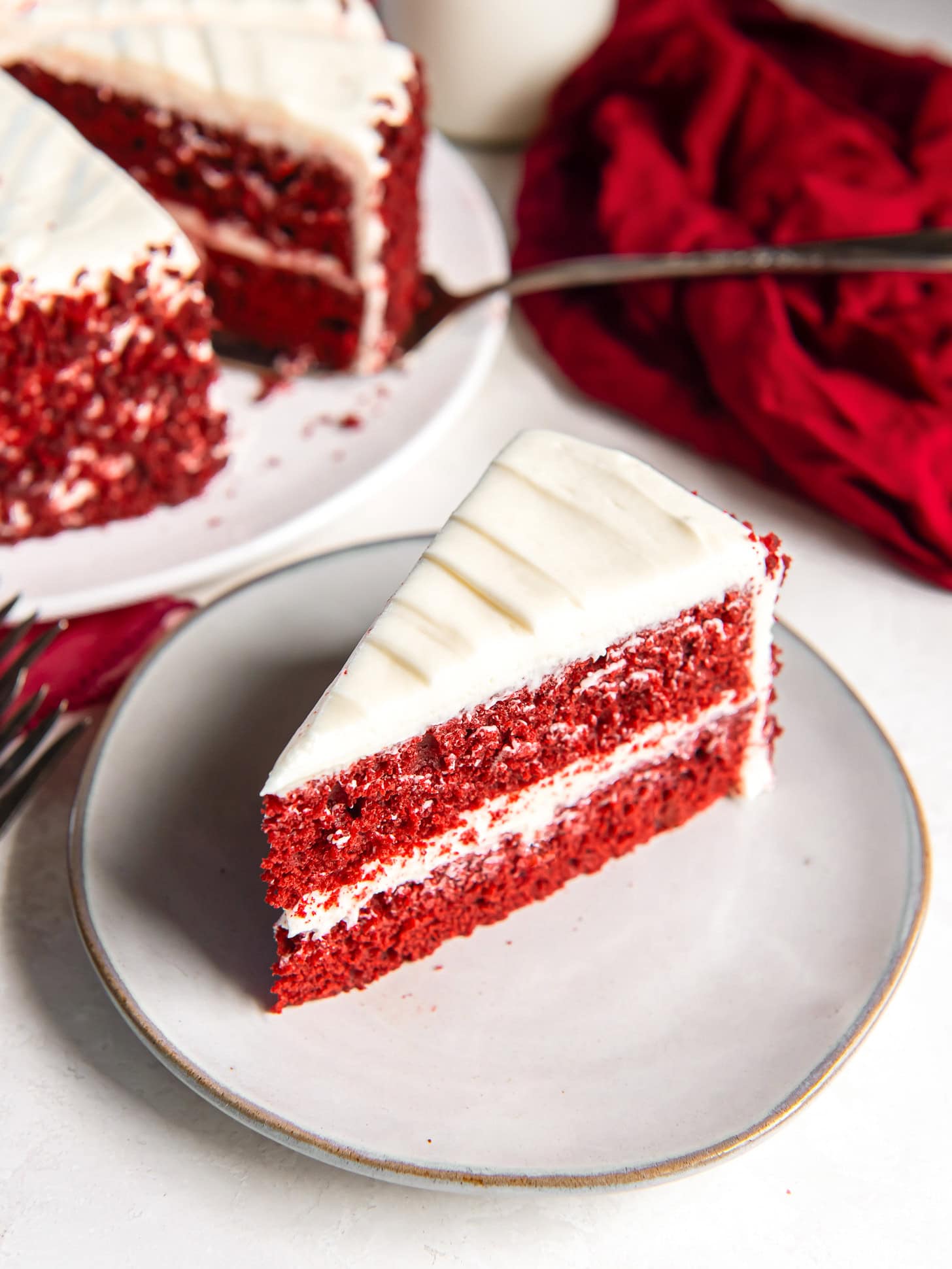 Slice of red velvet cake on a white plate.