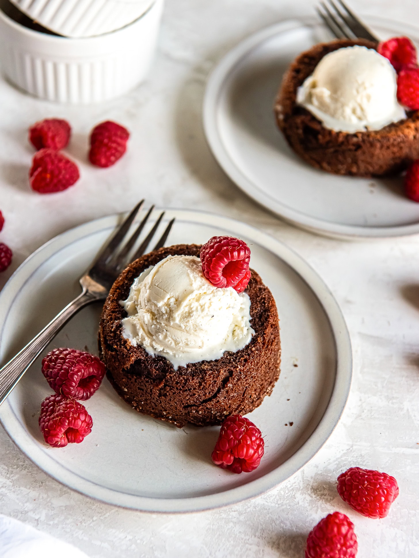 Chocolate lava cakes for two topped with vanilla ice cream.