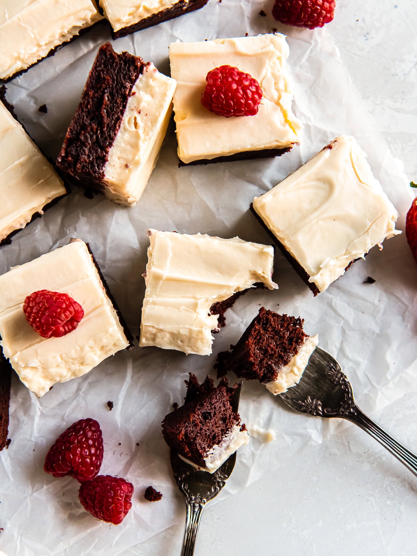 Frosted red velvet cookie bars with a bite on a fork.