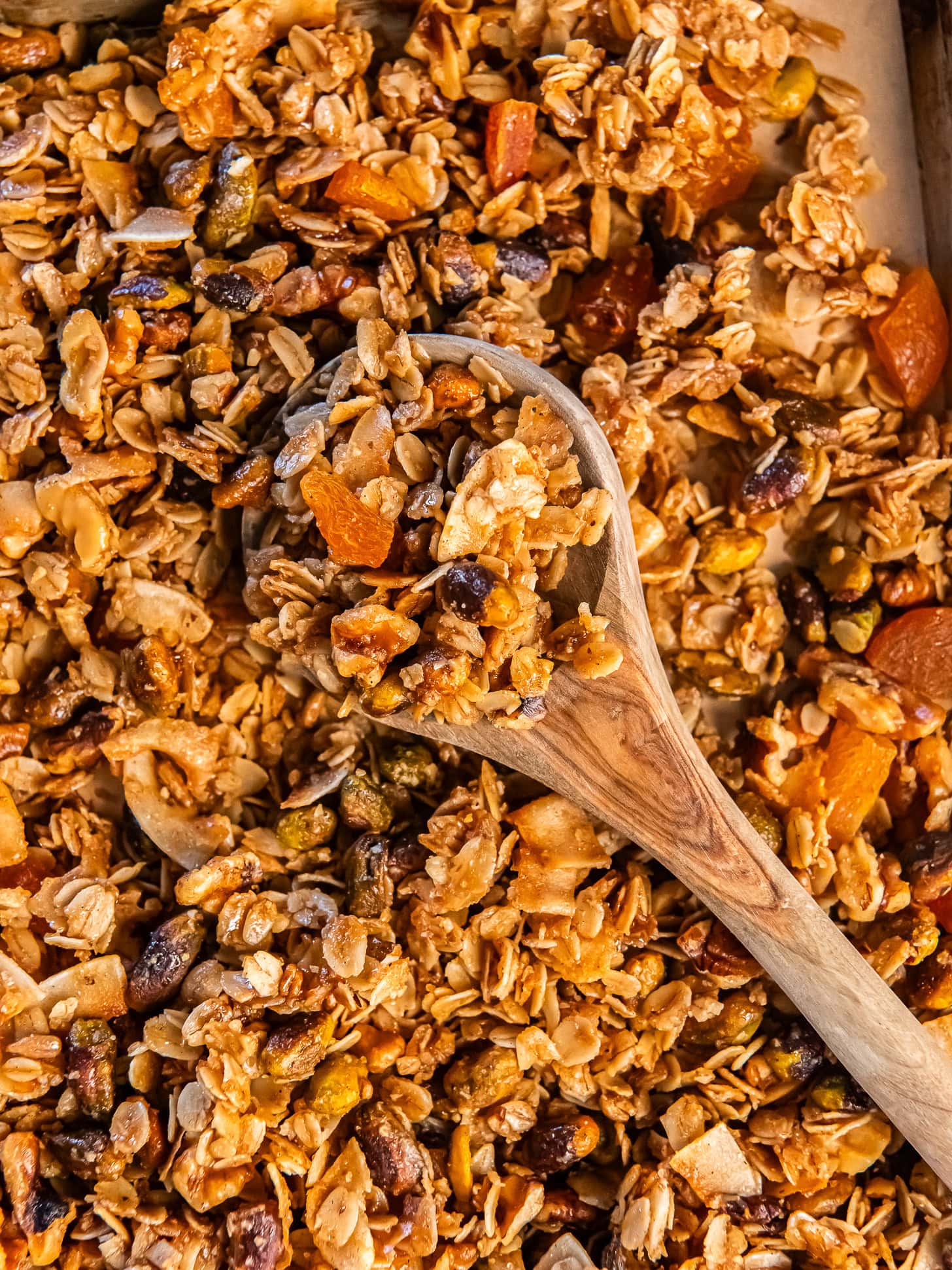 Wooden spoon on a pan with granola.