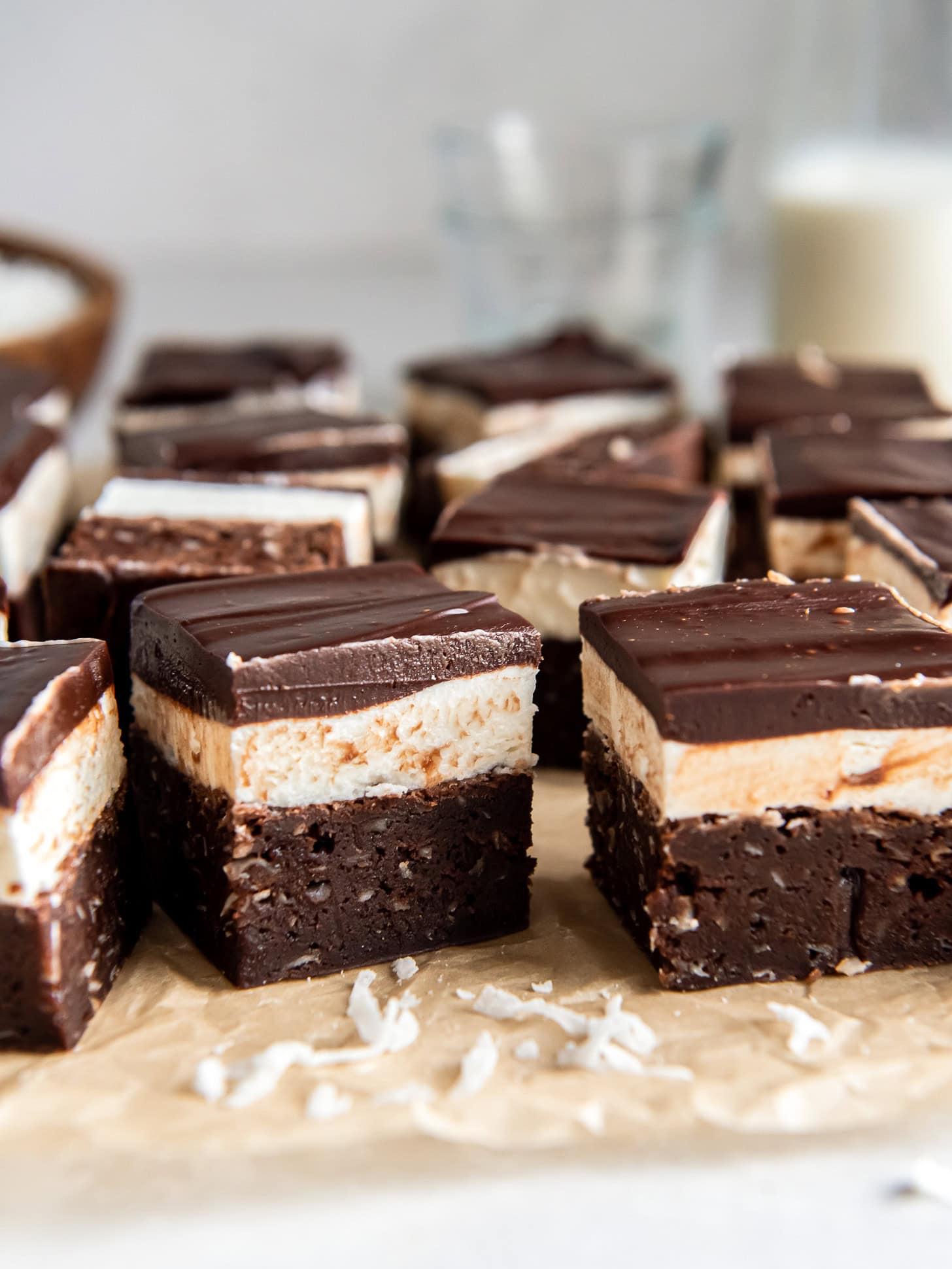 Brownies with a layer of coconut frosting and topped with ganache. 