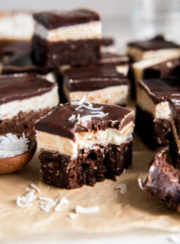 Coconut brownies with a bite taken out of one.