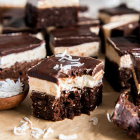 Coconut brownies with a bite taken out of one.