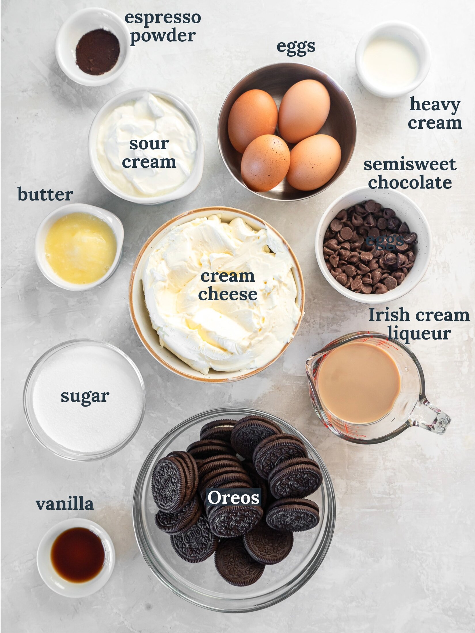 Small bowls with Oreos, cream cheese, eggs, sour cream, sugar and vanilla.