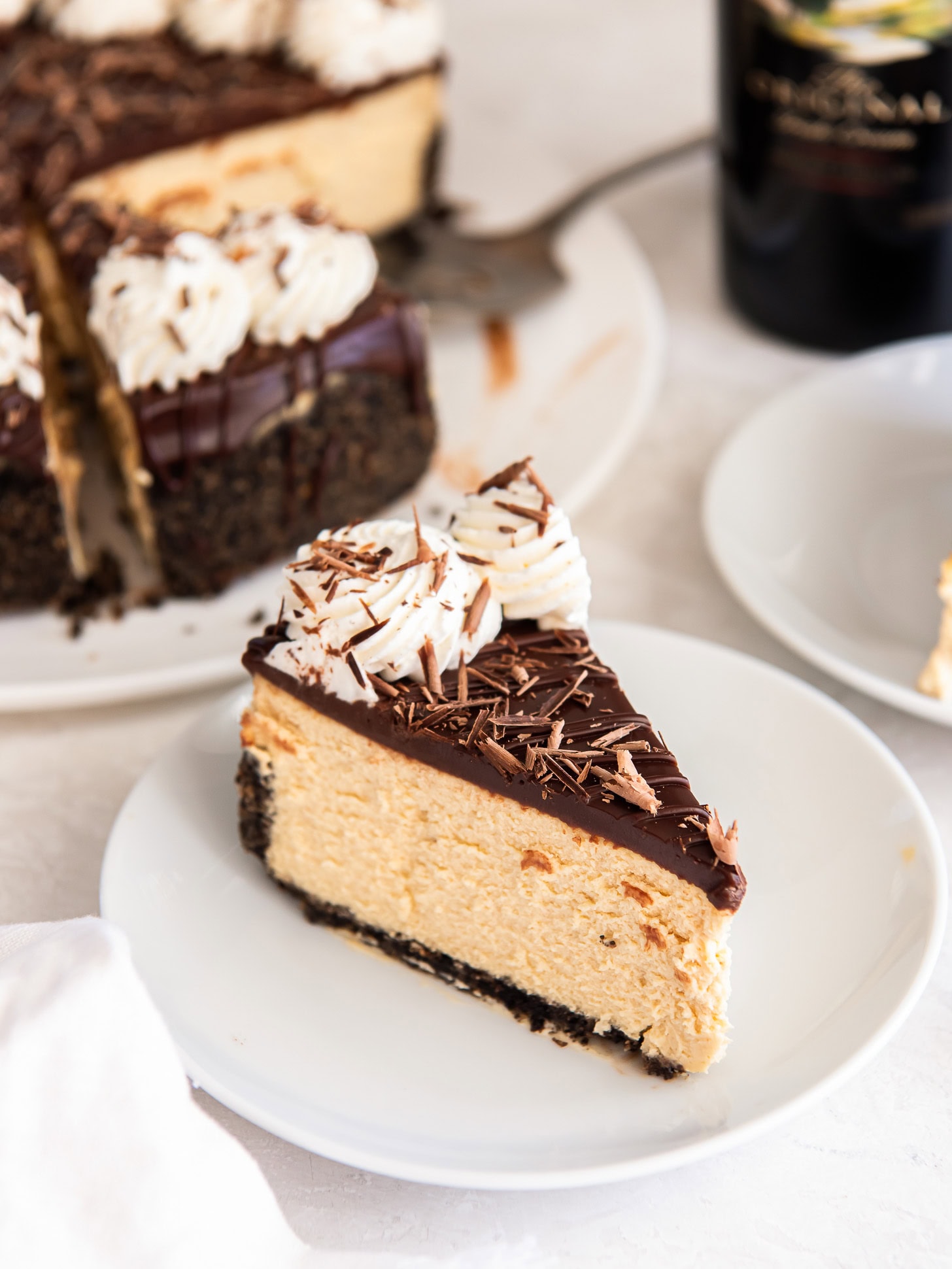 Slice of Irish cream cheesecake on a white plate.