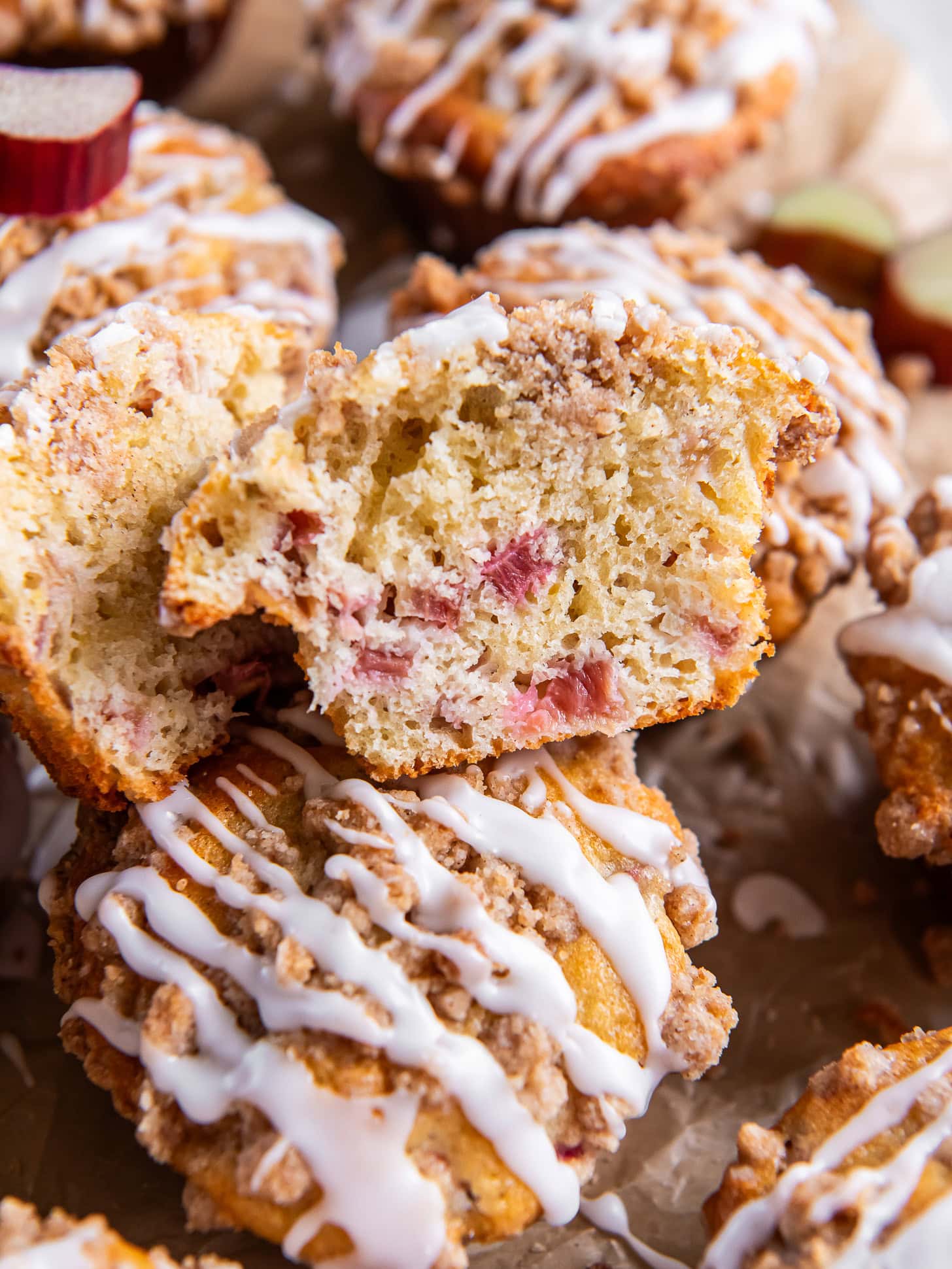 Rhubarb muffins with glaze with one cut in half.