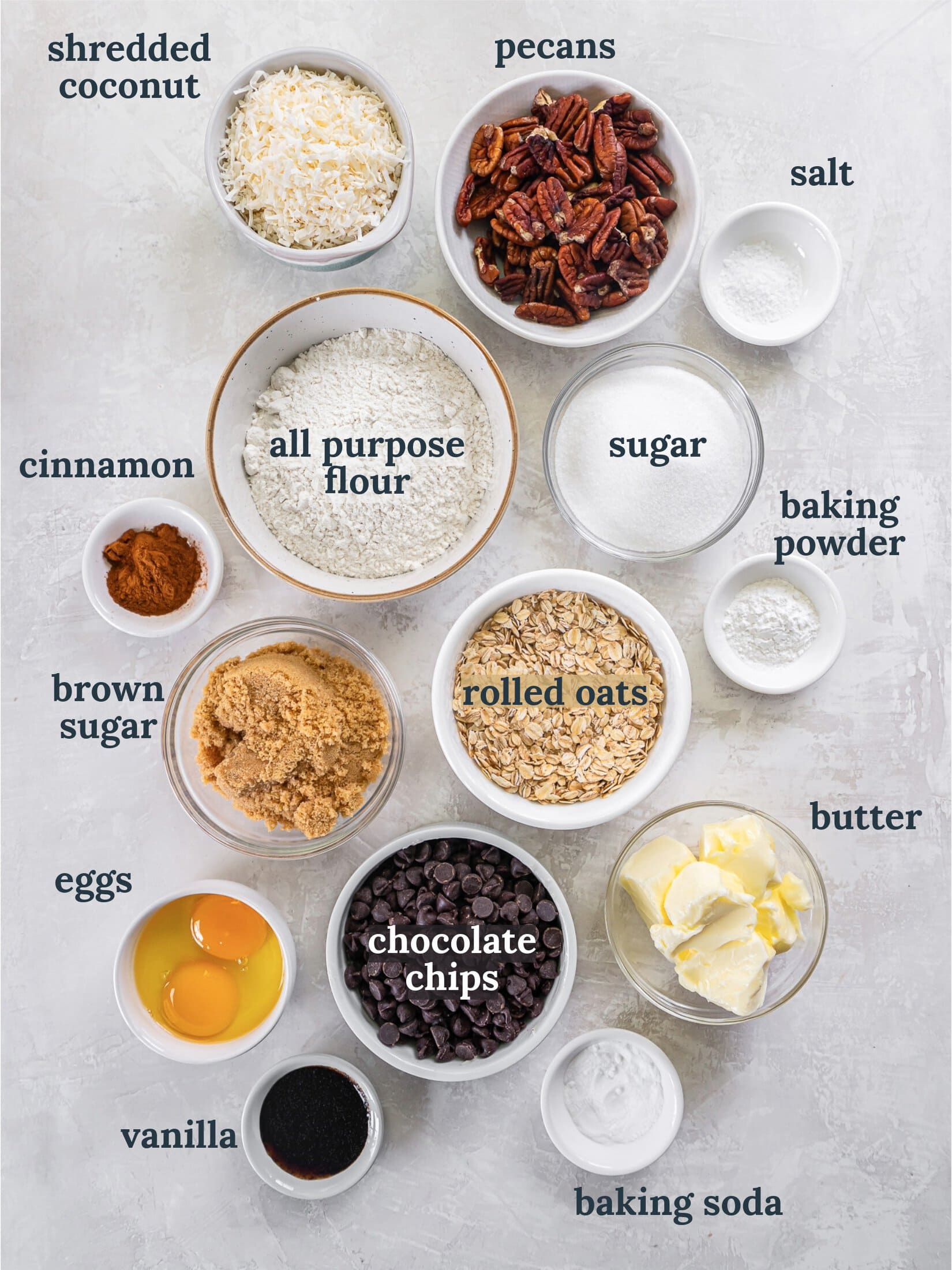 Small bowls with flour, sugar, chocolate chips, eggs, and butter.