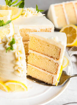 Serving a slice of lemon layer cake off a plate.