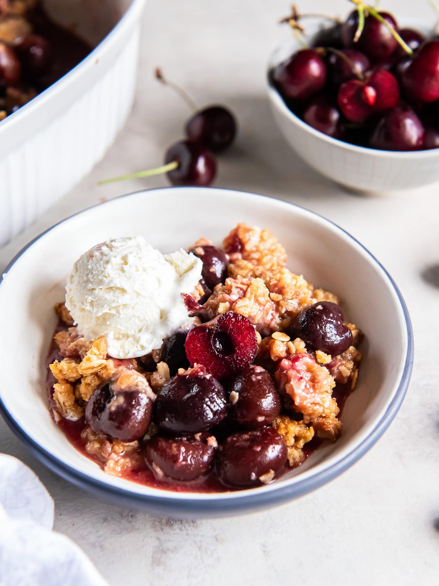 Cherry crisp served with a scoop of vanilla ice cream.