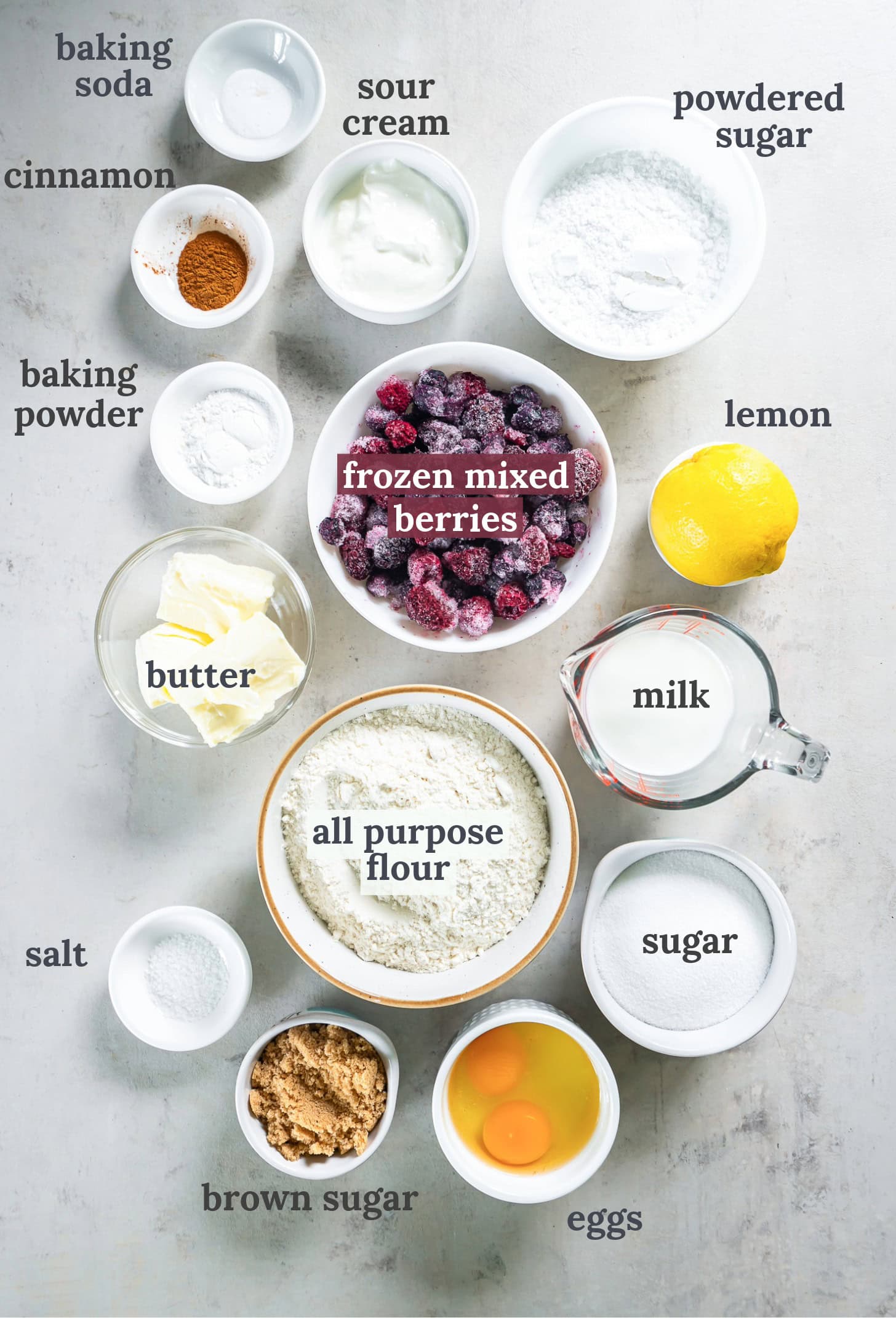 Bowls with mixed berries, flour, sugar, eggs, butter and milk.