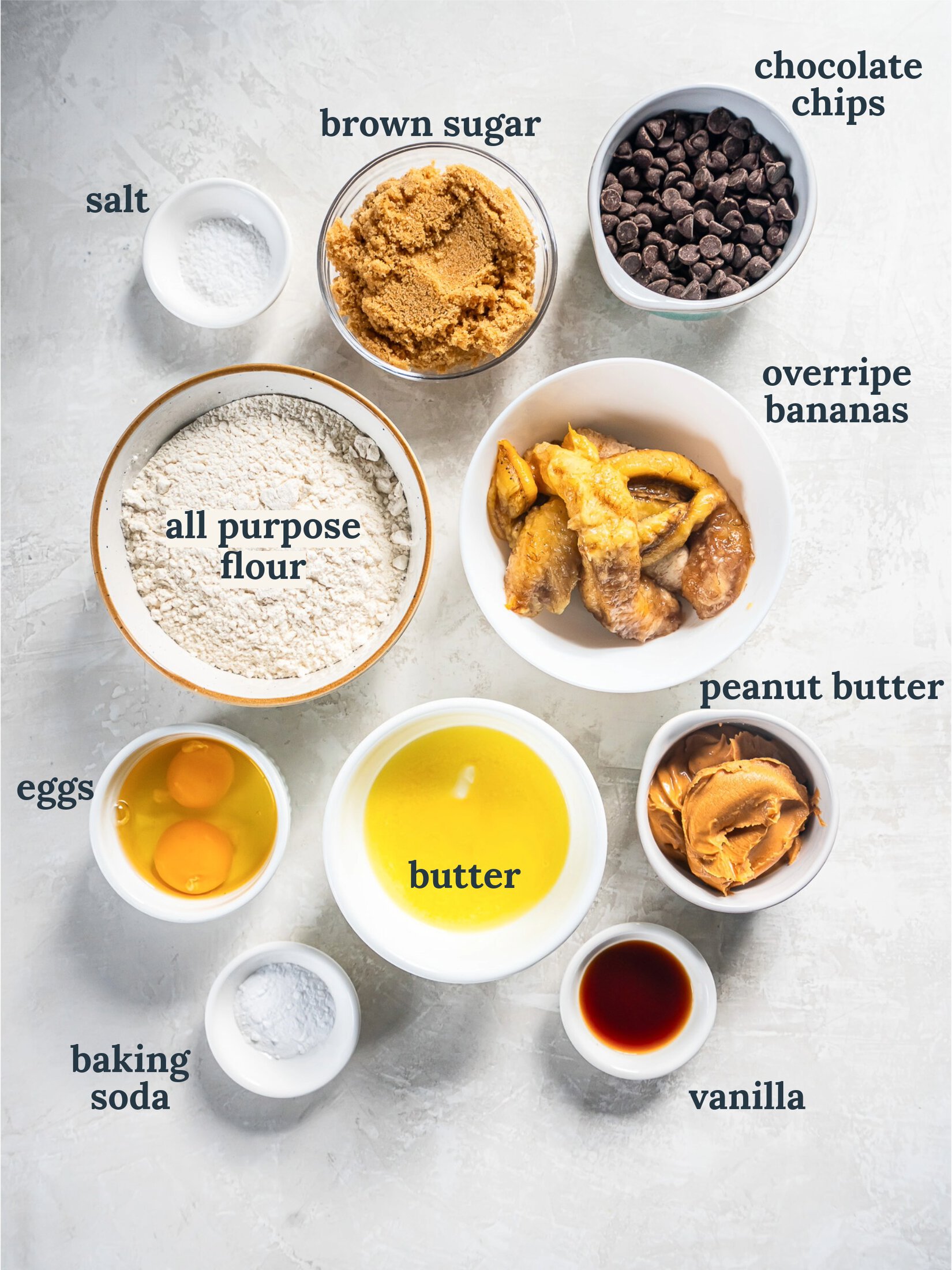 Small bowls with flour, peanut butter, eggs, butter and chocolate chips.
