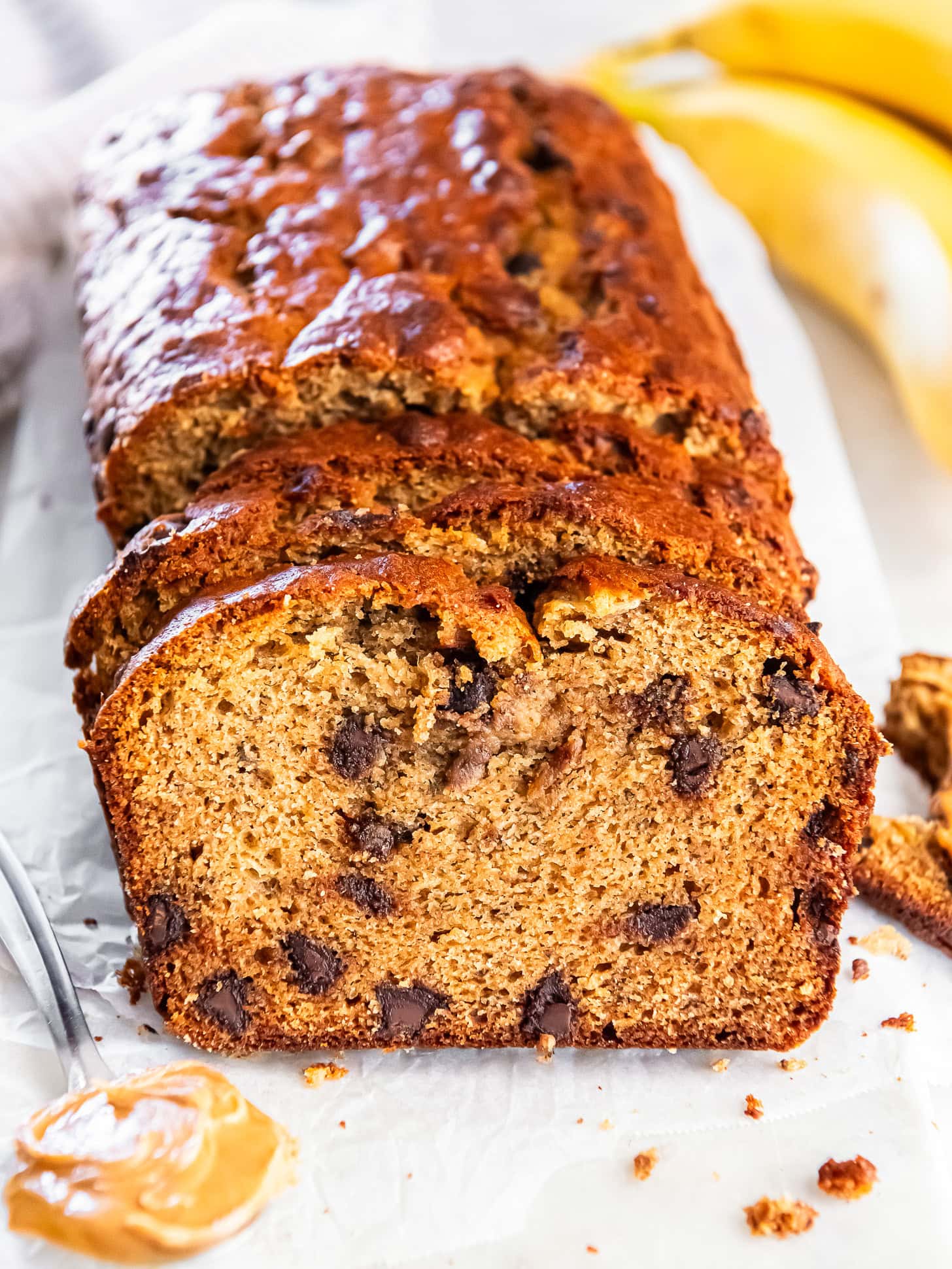 Sliced loaf of peanut butter banana bread with chocolate chips.