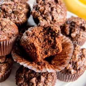 Bite taken out of a double chocolate banana muffin.