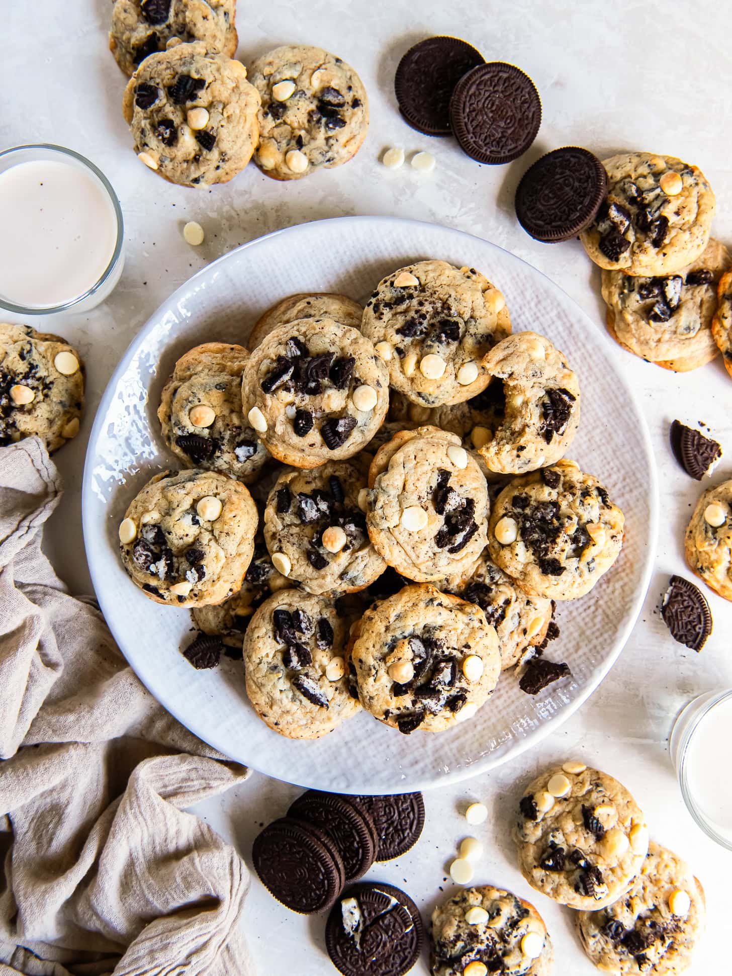 Cookies and cream cookies on a white plate near Oreo cookies.