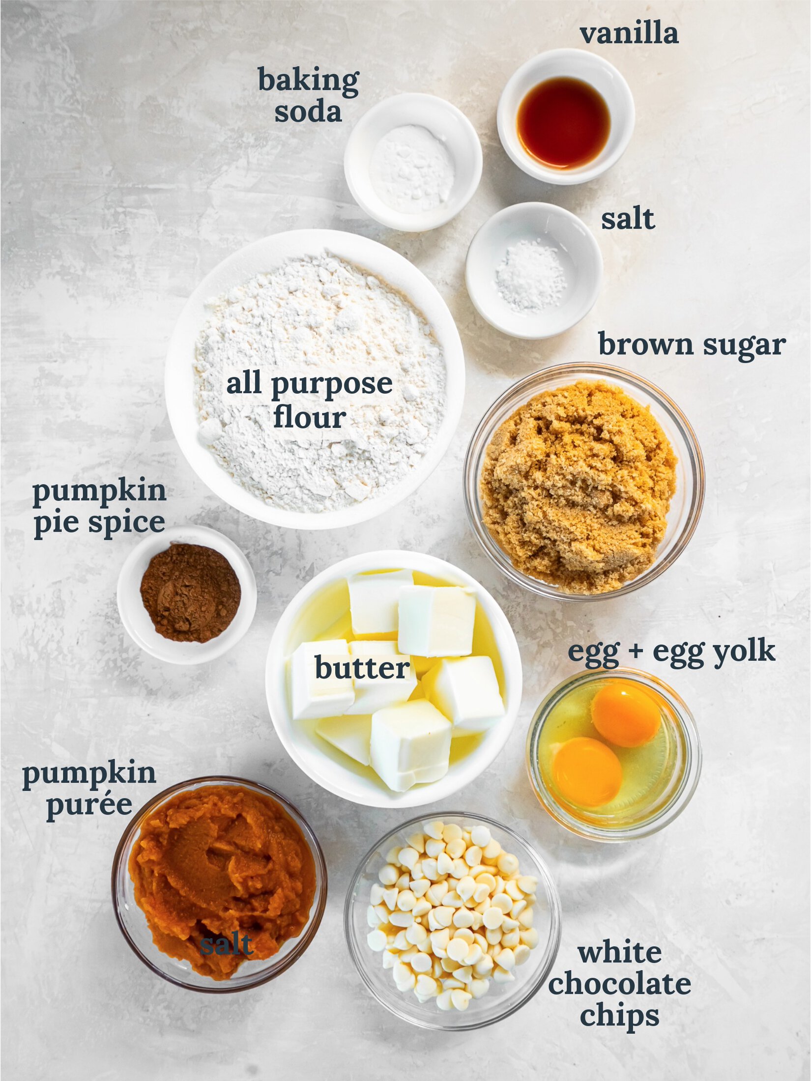 Small bowls with flour, butter, sugar, pumpkin, eggs, and chocolate chips.