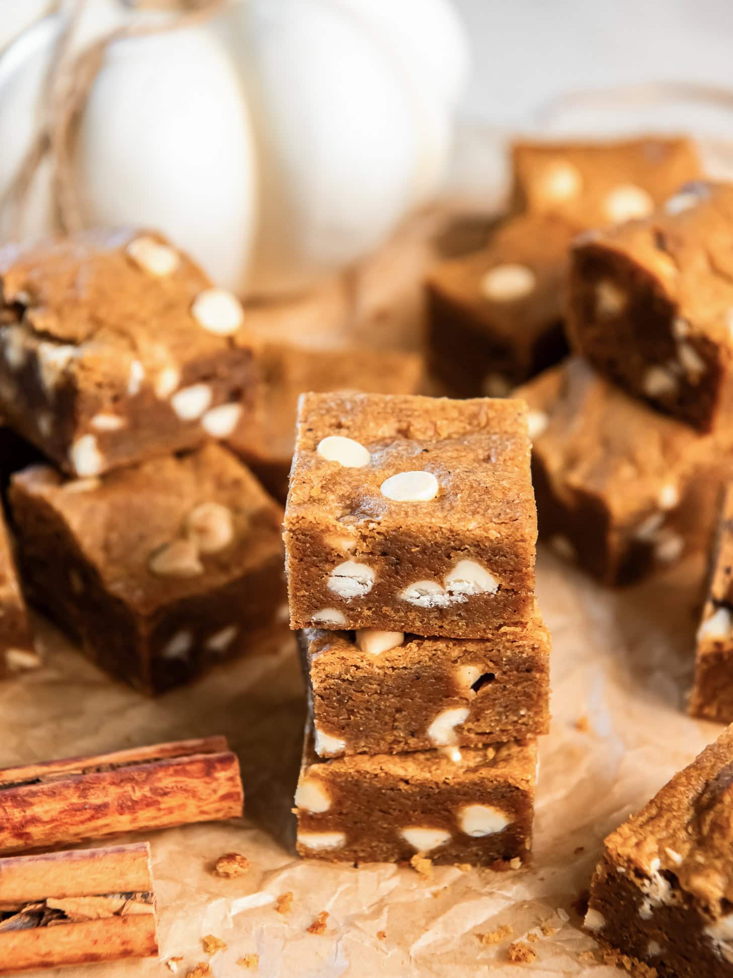 Stacked pumpkin blondies with white chocolate chips.