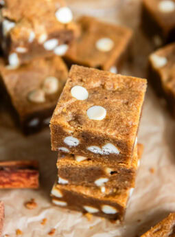 Stacked pumpkin blondies with white chocolate chips.
