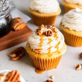Maple cupcakes topped with frosting and chopped pecans.