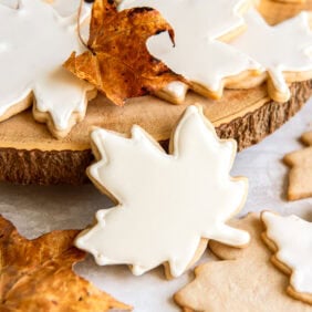 Maple leaf sugar cookies decorated with a white icing.