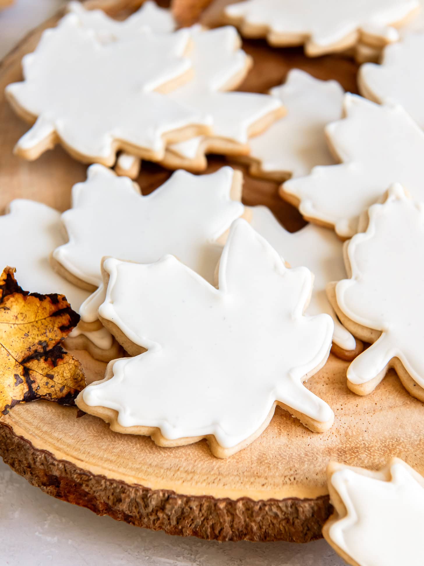 Iced maple leaf sugar cookies stacked.
